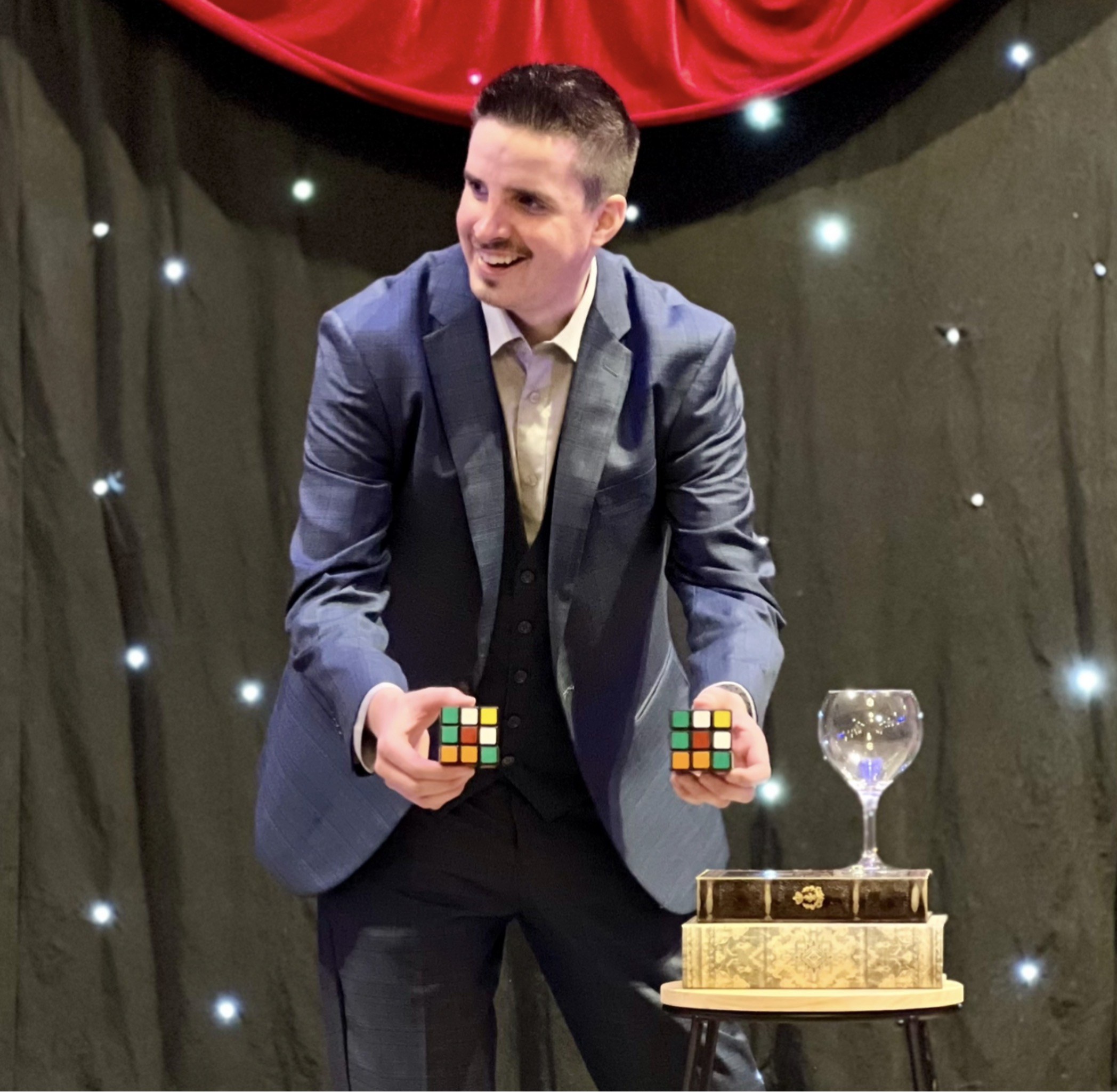 Neal Chamberlain holding matching Rubik’s Cube predictions during a corporate event