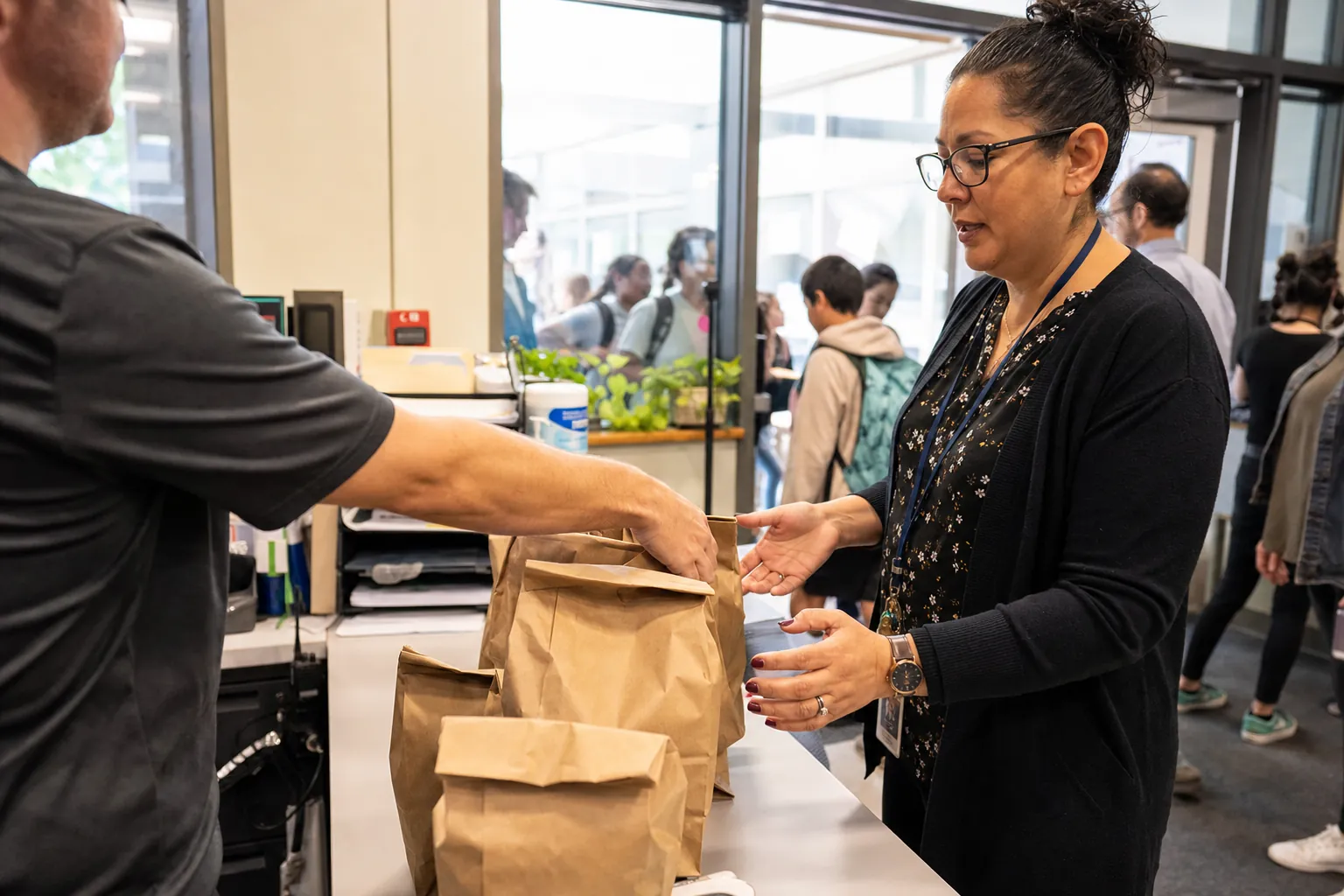 Restaurant delivery bags being handed to school staff at lunch handoff.