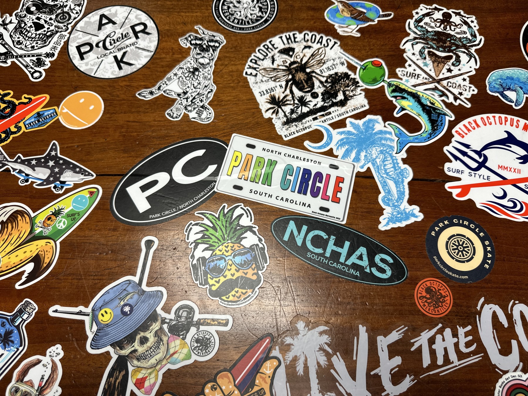 Original Black Octopus coastal stickers and artwork arranged on a wooden tabletop