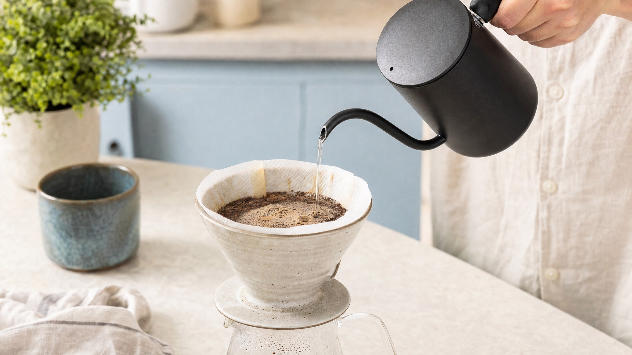 Hot water poured over blooming coffee grounds in a ceramic dripper