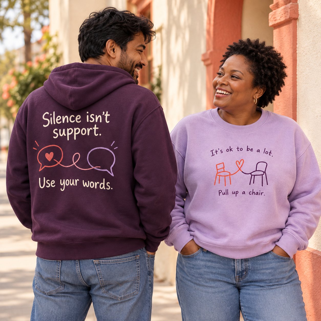 Two people sharing a smile in plum and lavender statement sweatshirts