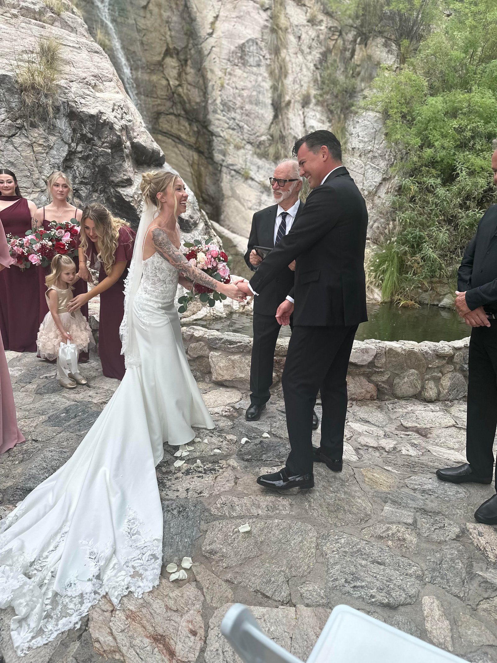 The Hunter couple holding hands during their ceremony with Edward and the bridesmaids