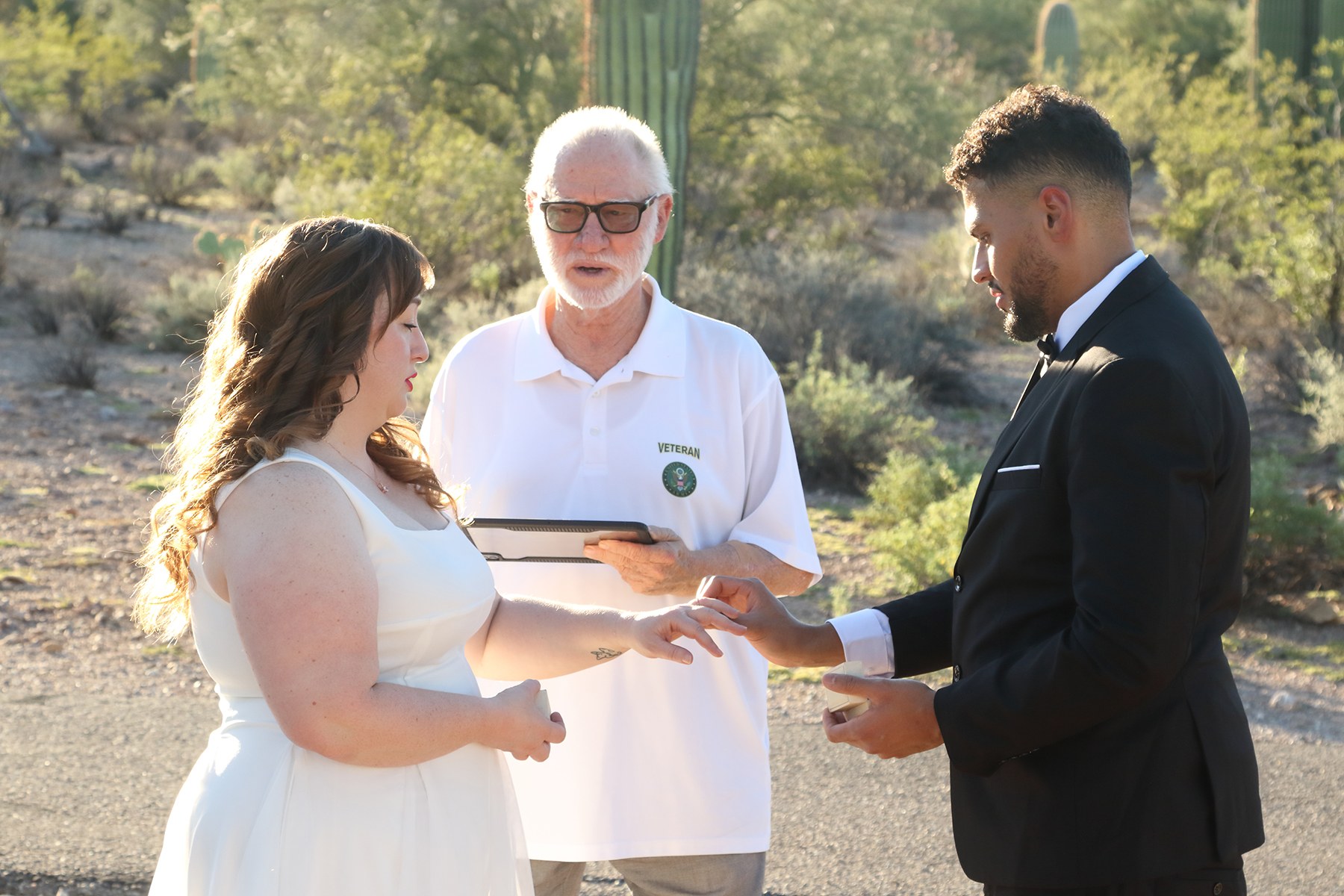 Edward guiding a couple through their ring exchange in the desert