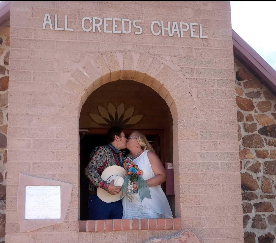 Peggy and her spouse kissing at All Creeds Chapel