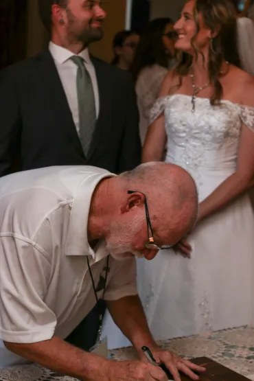 Edward signing a marriage license with a newlywed couple