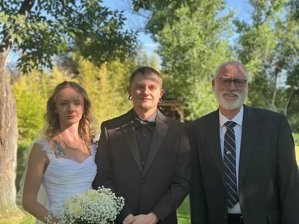Edward standing with a newly married couple