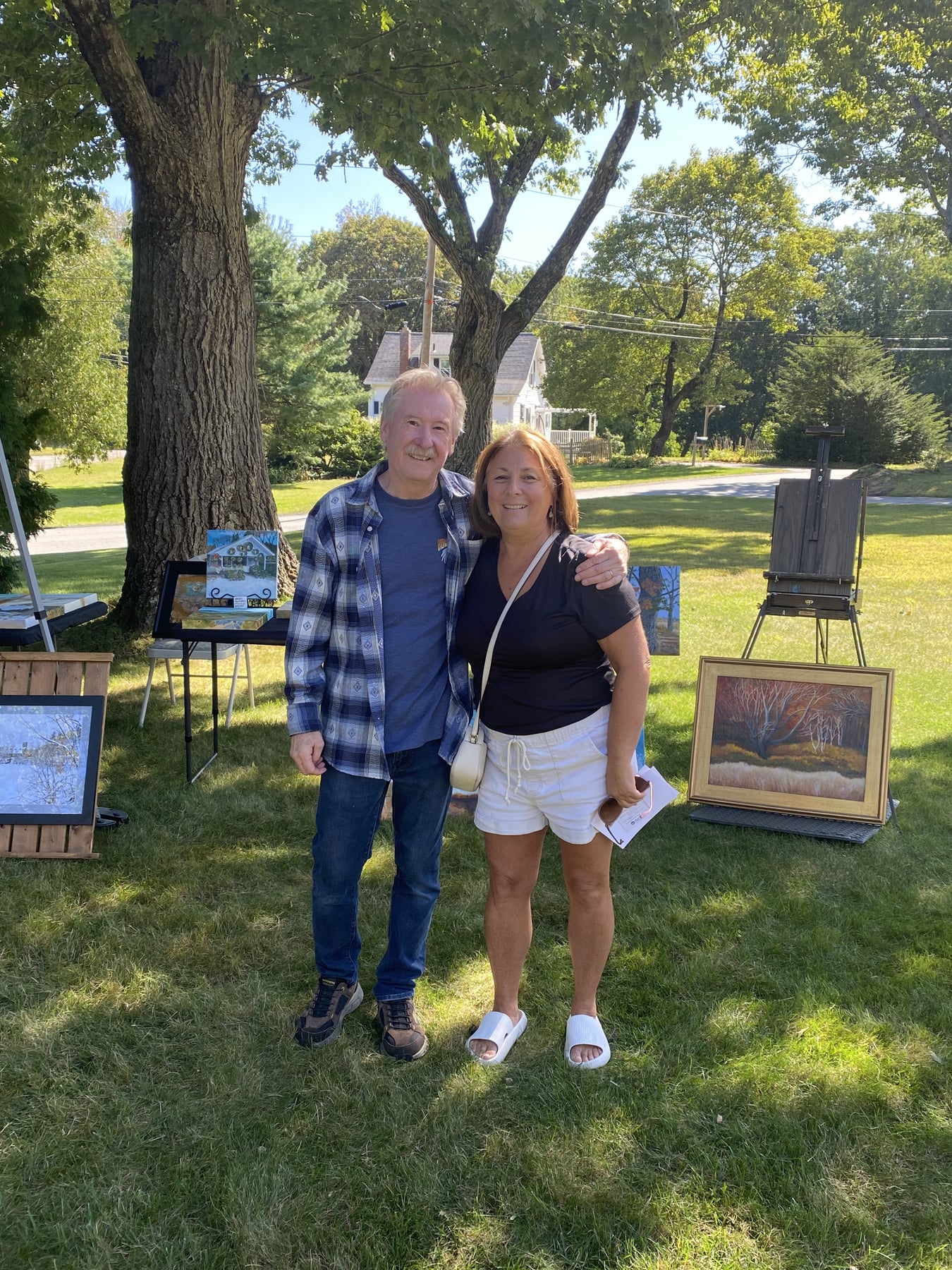 Two guests standing among paintings at the 2026 Autumn Art Sale.