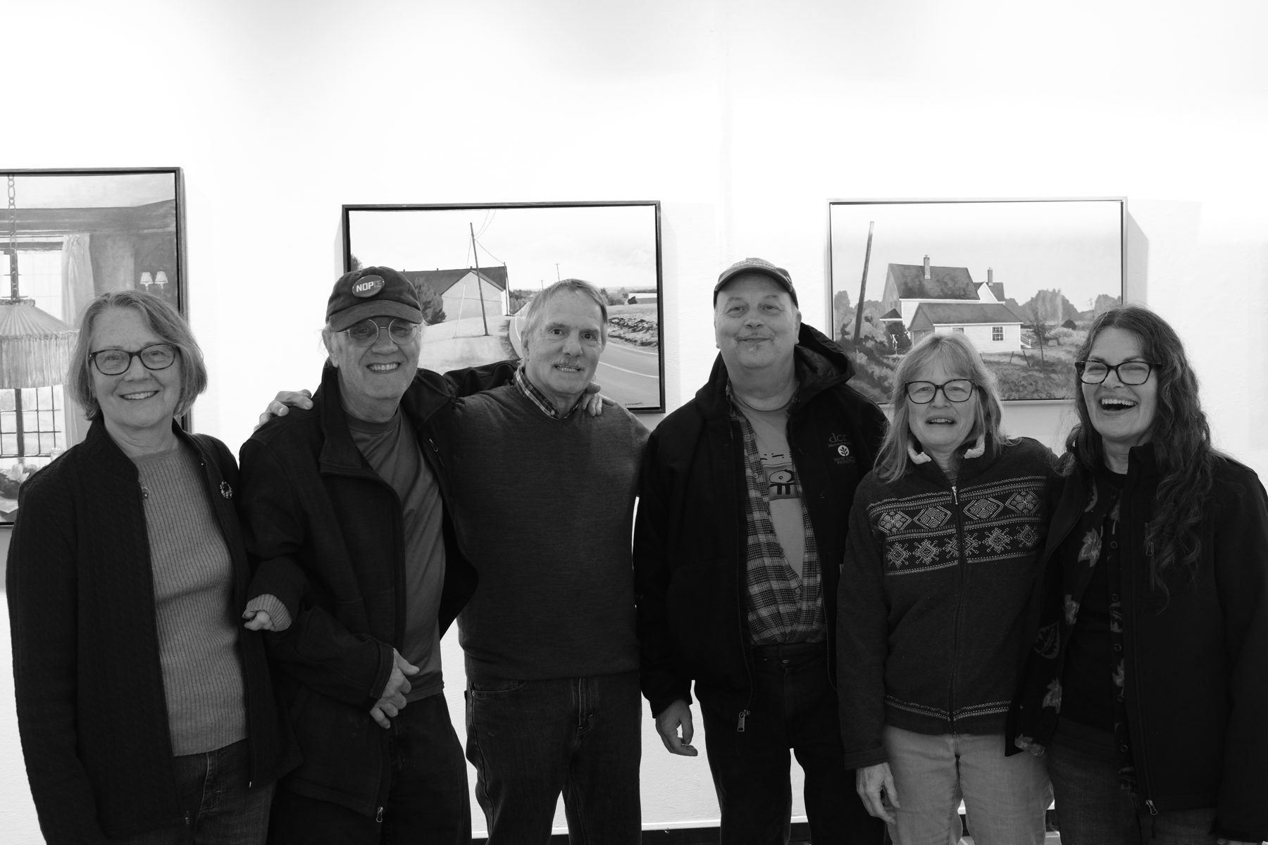 A group of guests in front of paintings at Circumstantial Light