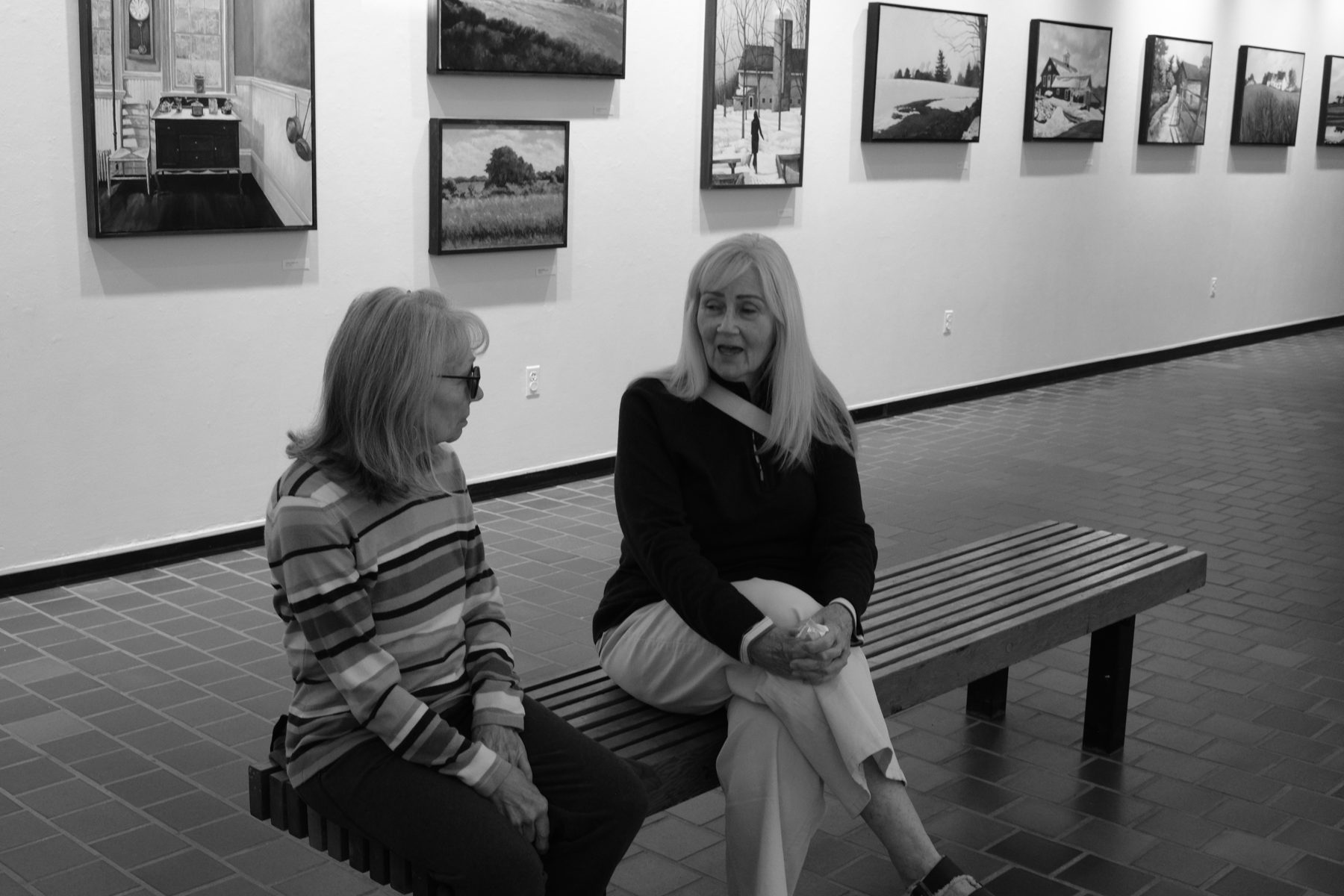 Two visitors seated in the East Wing Gallery