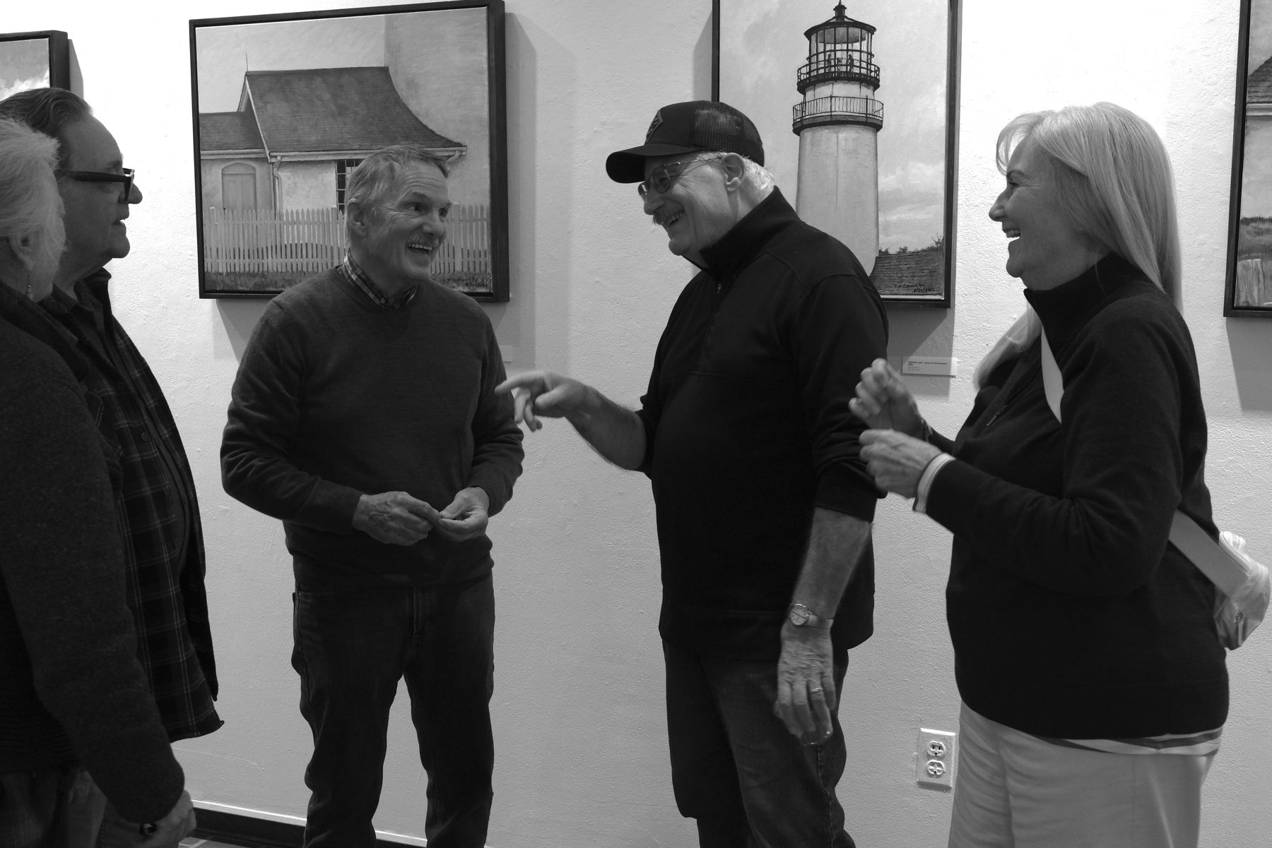 Visitors talking among the paintings at Circumstantial Light