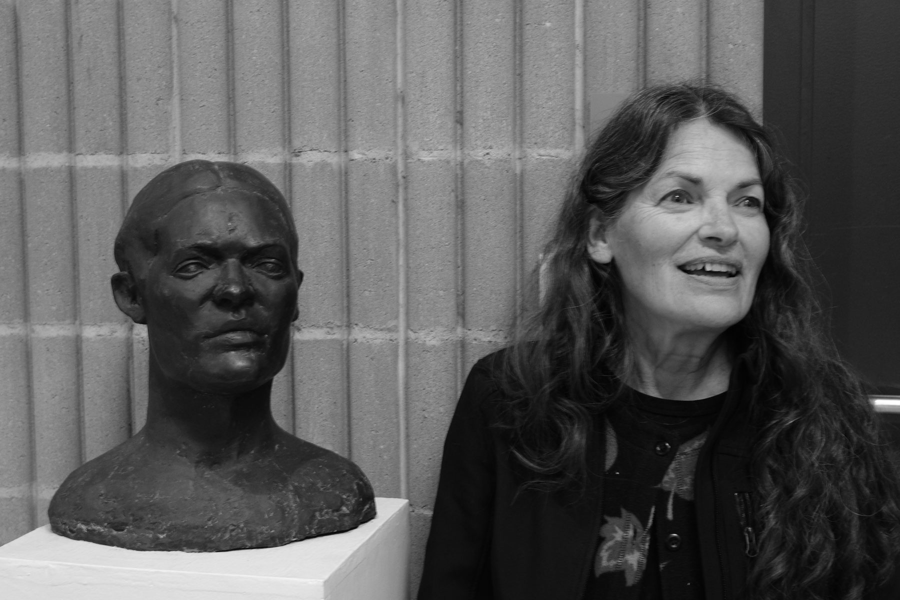 A visitor beside a sculpted portrait bust at the exhibition