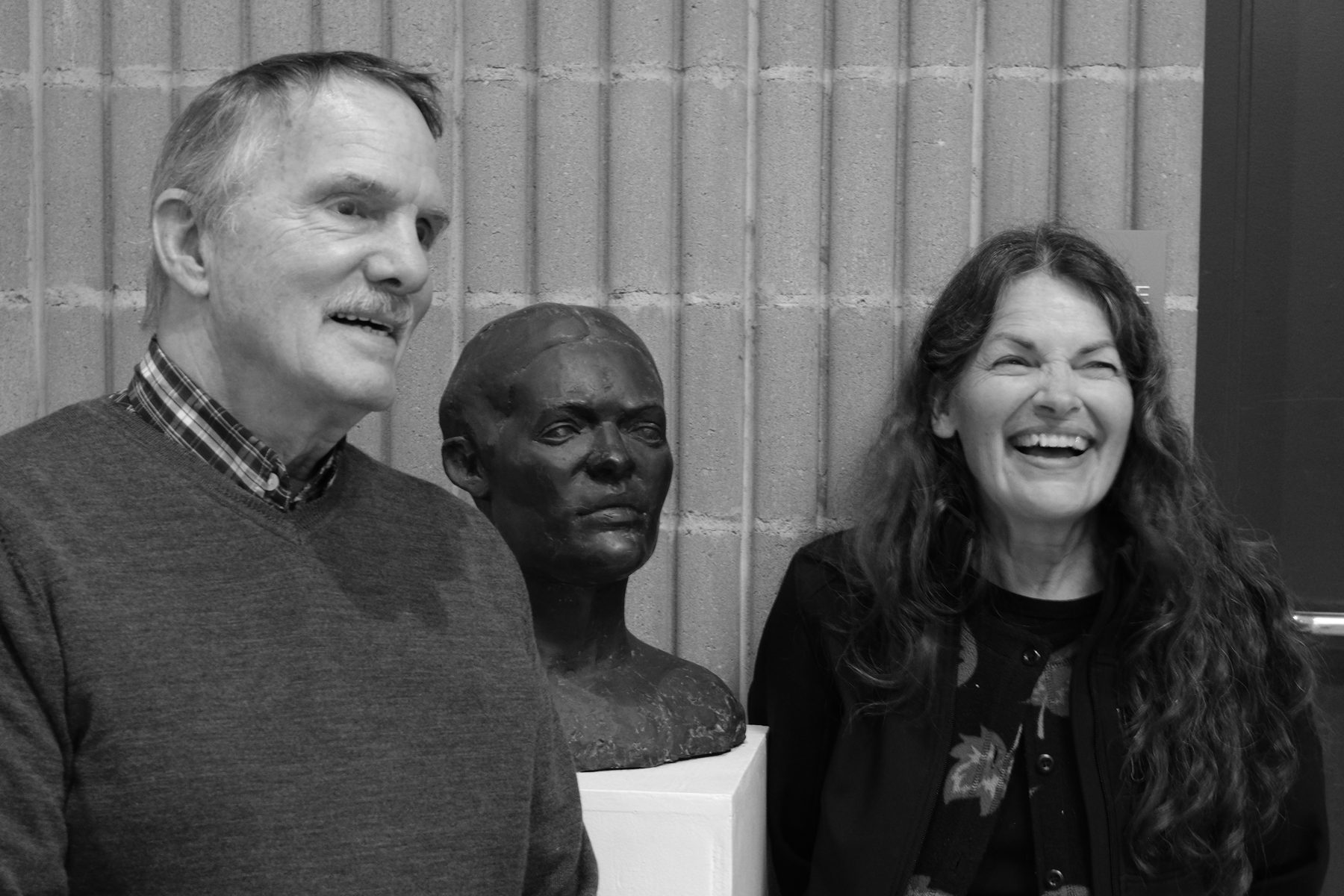 Two guests beside a portrait bust at Circumstantial Light
