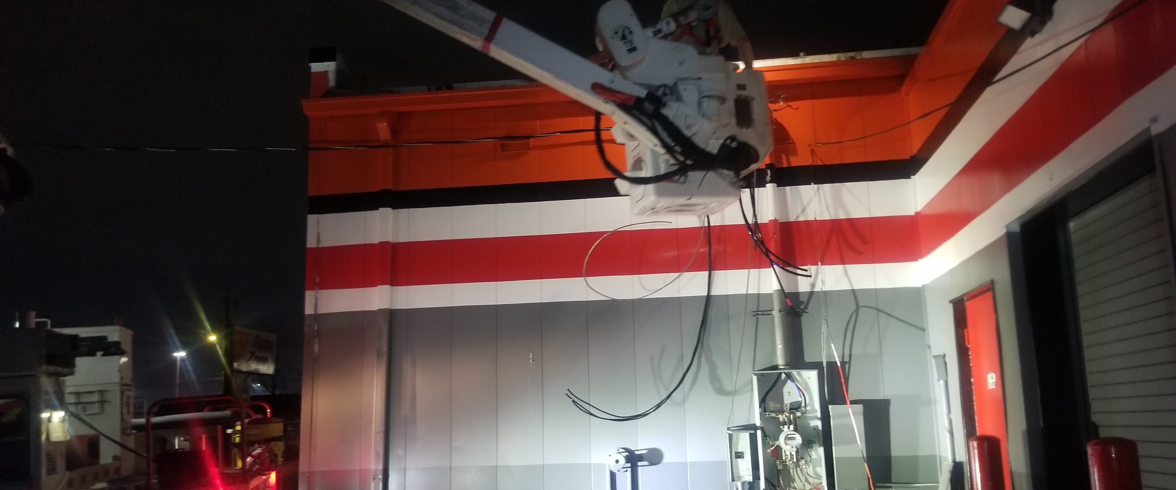 Mister Volts bucket truck completing an electrical installation at night