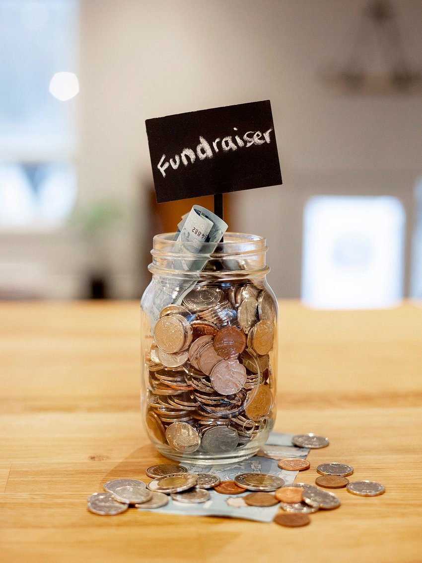 Fundraiser donation jar filled with coins and cash