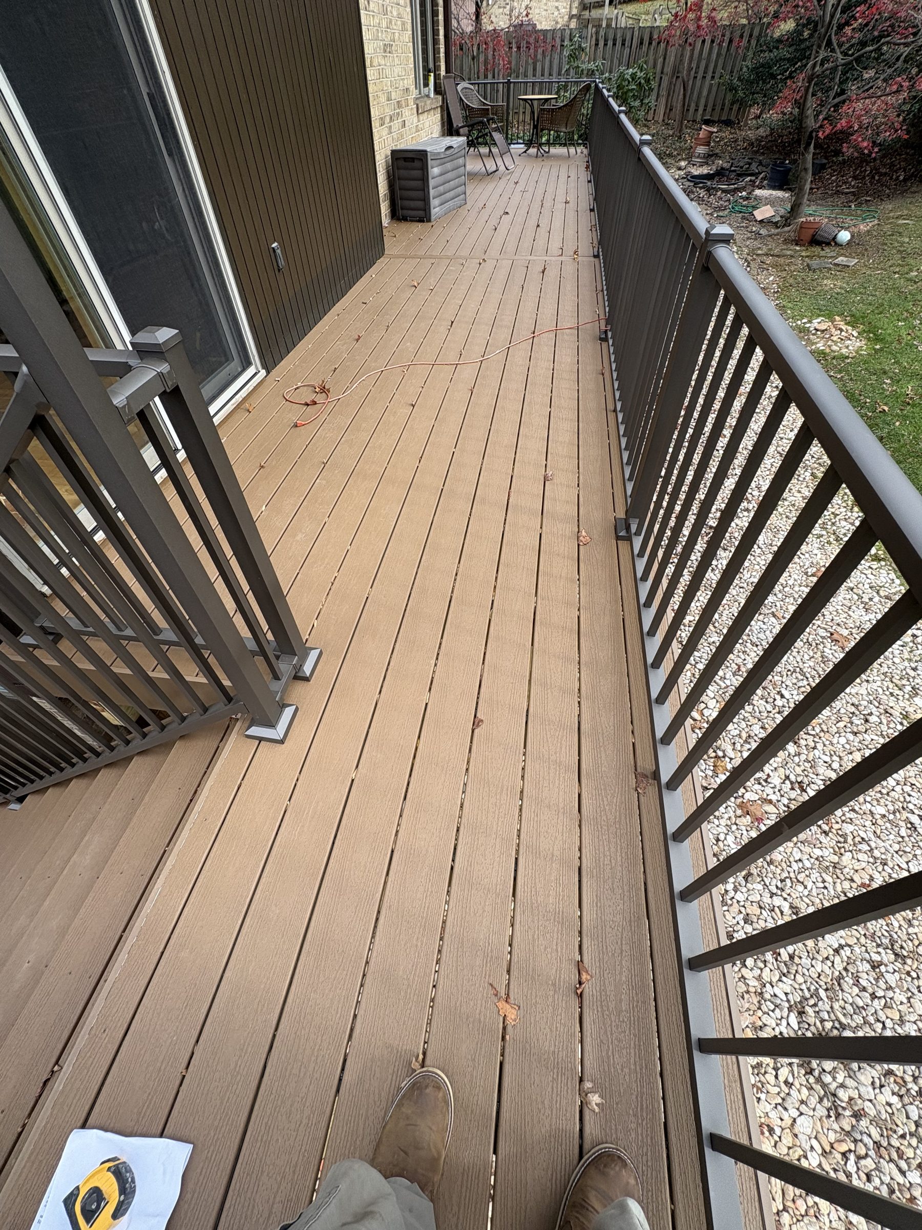 Brown deck surface and dark railings with an outdoor seating area