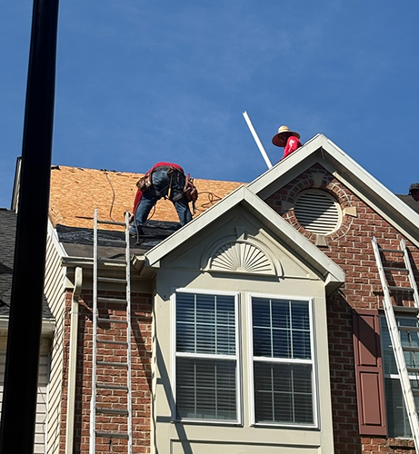 Roofing crew working on exposed roof decking