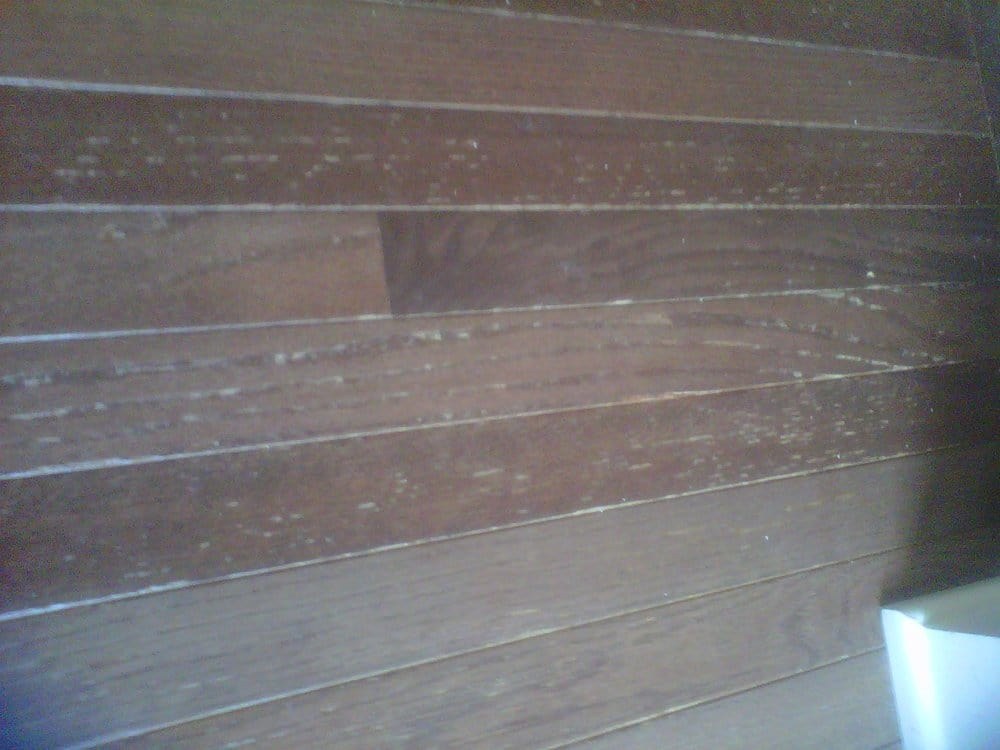 Close-up of surface wear and scratches on a dark wood floor