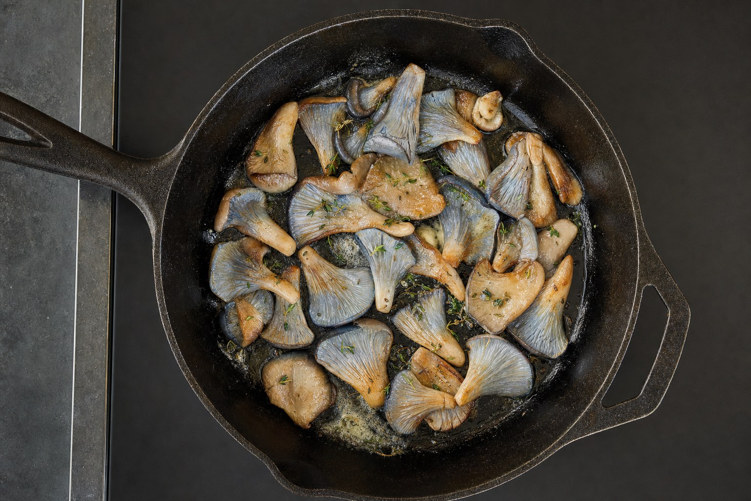 Blue oyster mushrooms sauteing in a cast-iron skillet