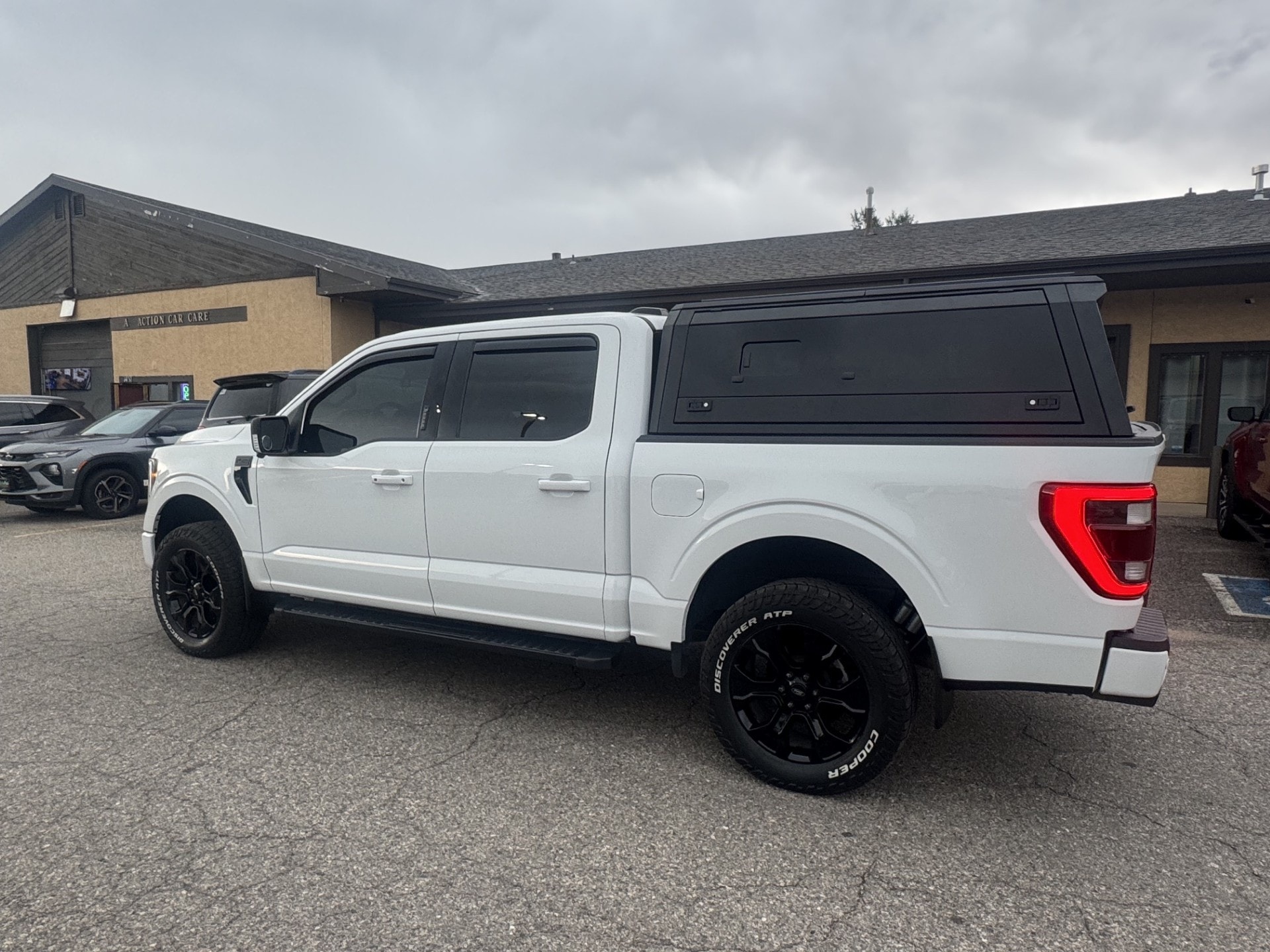 White Ford F-150 with a black aluminum truck cap