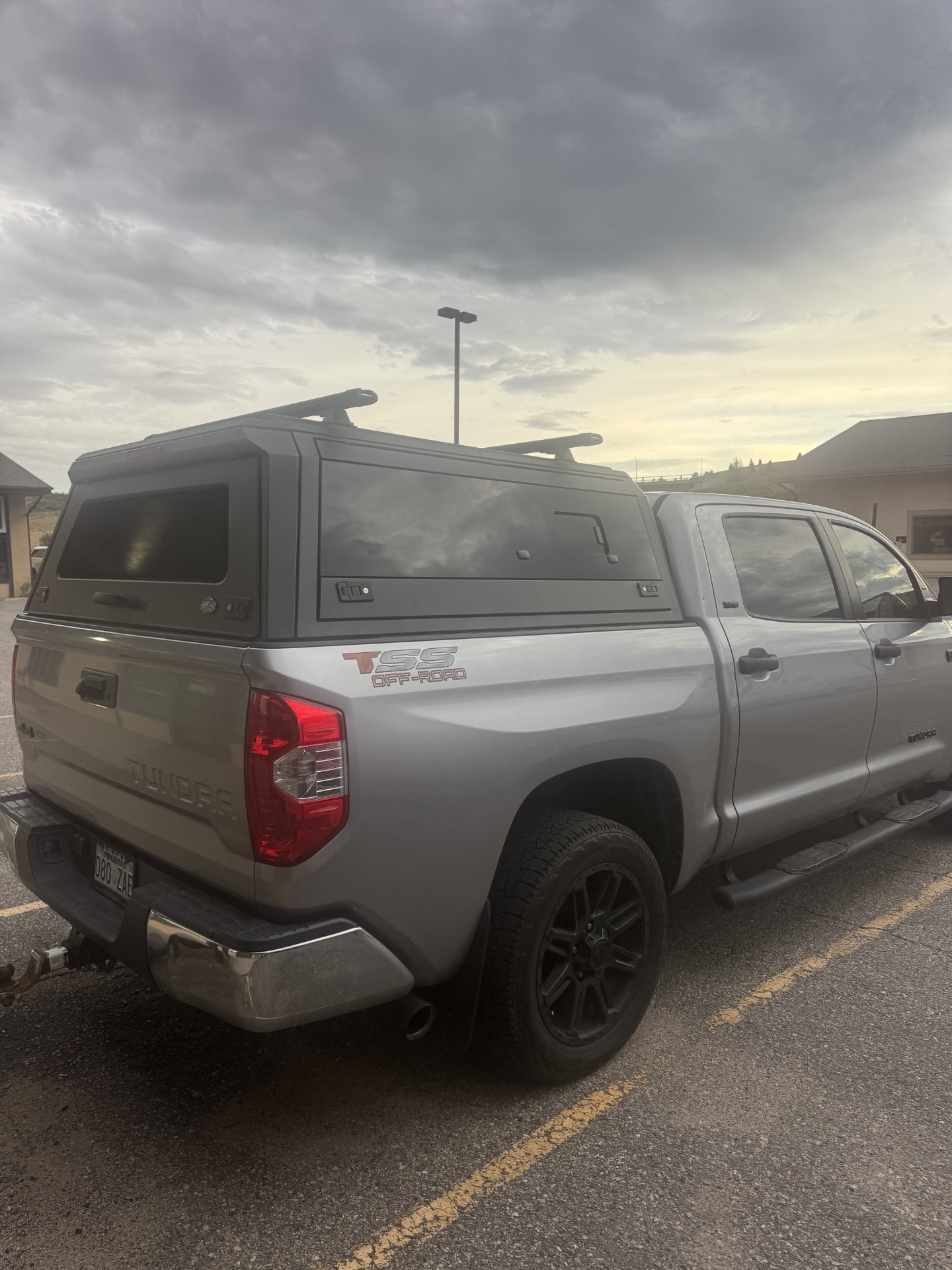 Silver Toyota Tundra with a black aluminum truck cap and roof bars