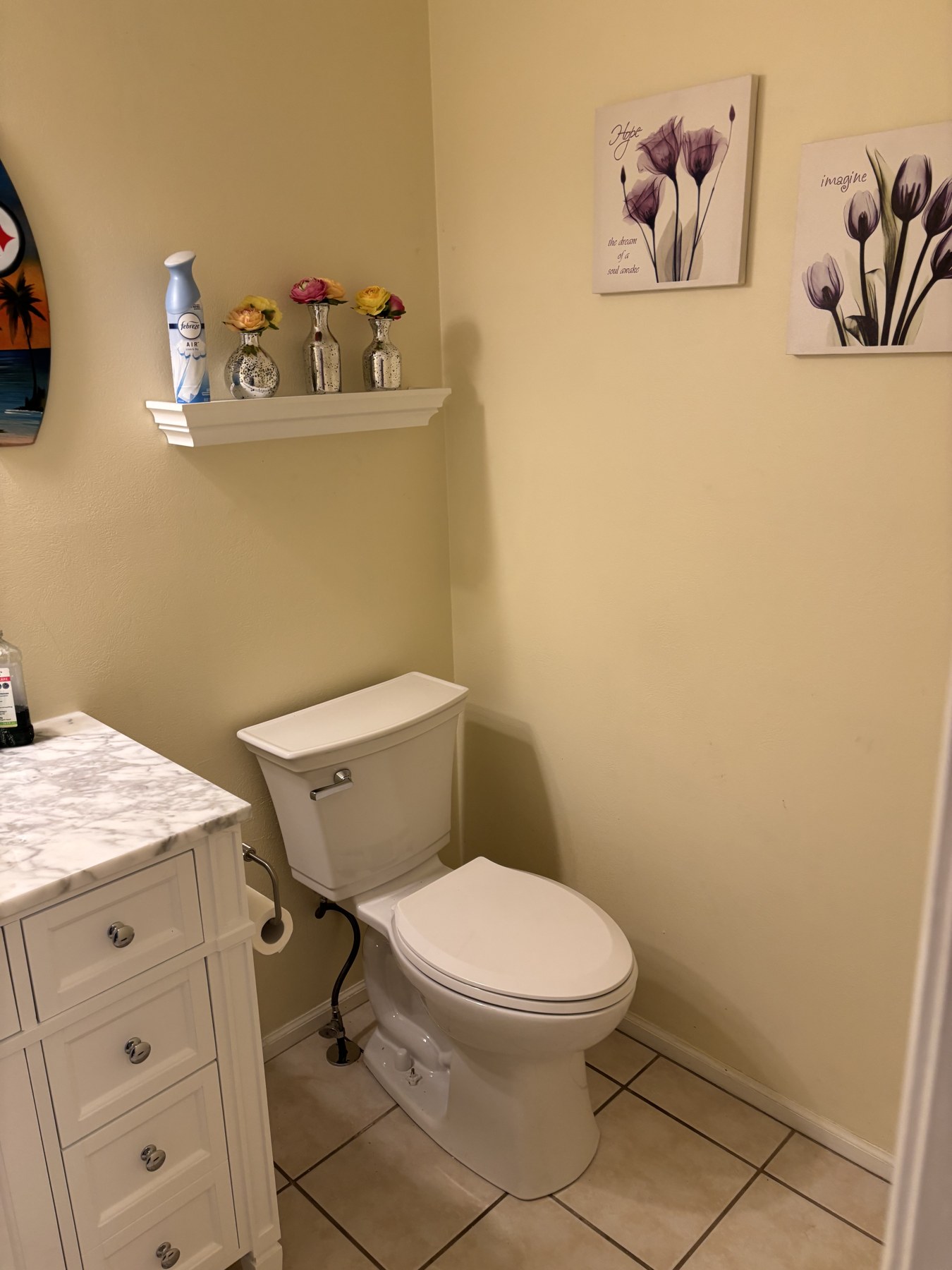 Bathroom with a white vanity, toilet and tiled floor.