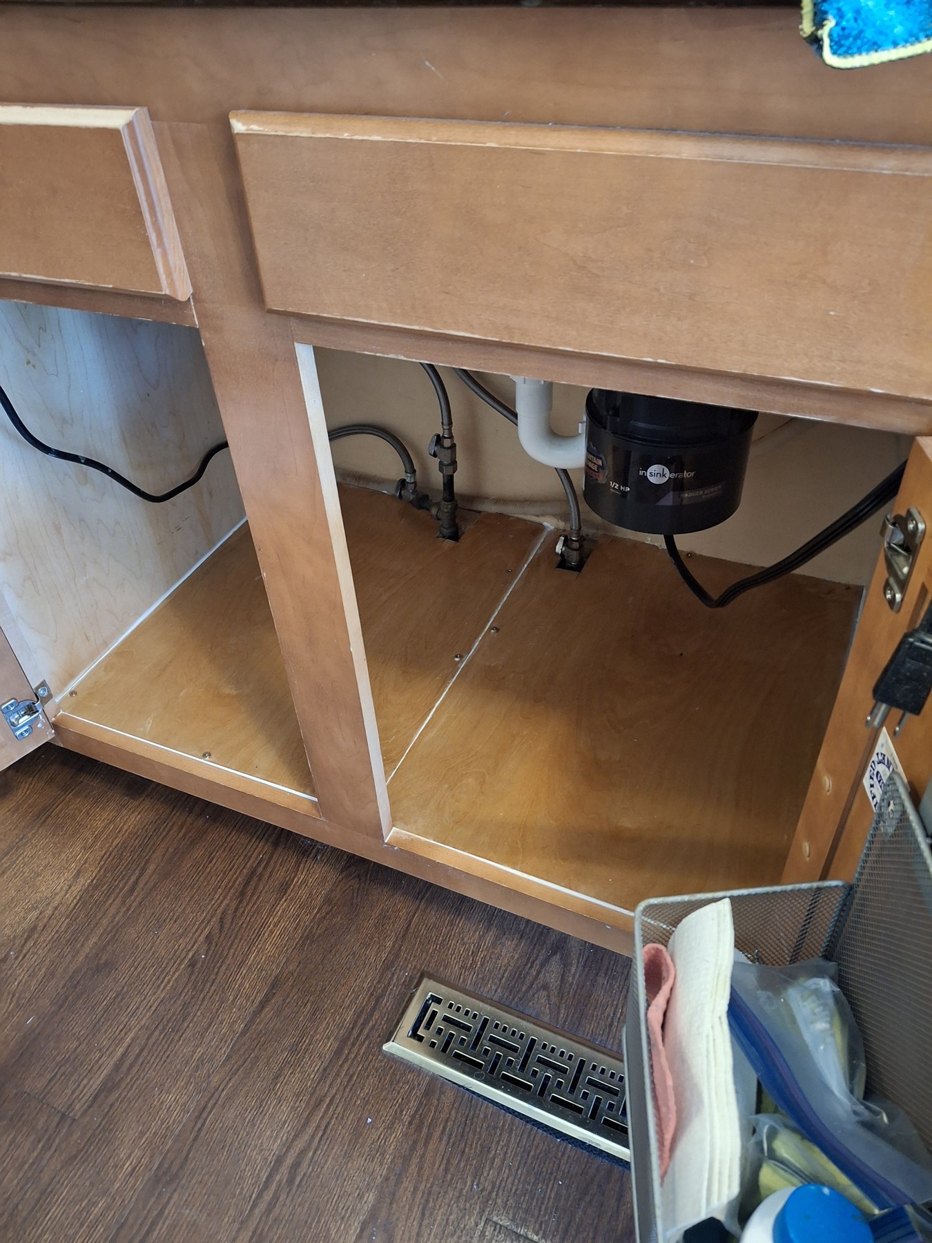 A closer look at the cabinet interior and plumbing beneath a kitchen sink.