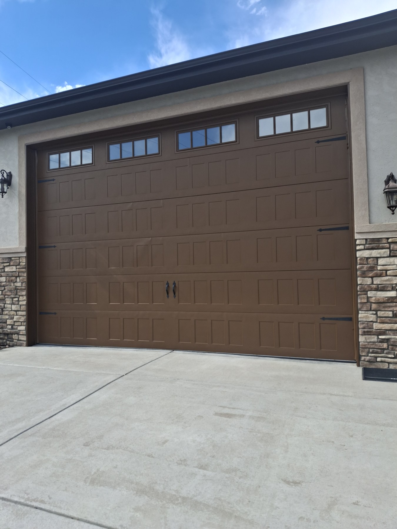 A wider view of the garage door and driveway.