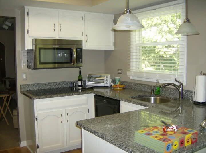 Kitchen with white cabinetry and dark countertops