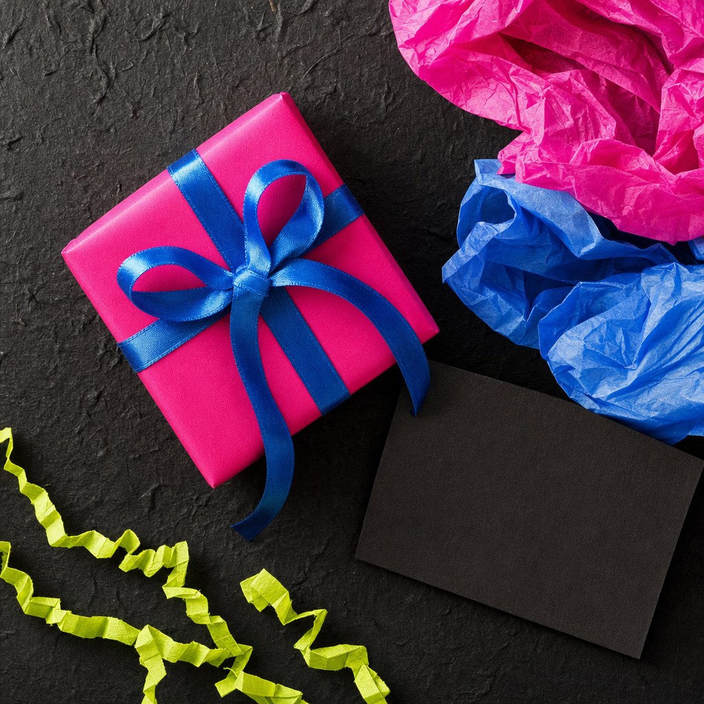 A hot pink wrapped gift with electric blue ribbon and colorful tissue paper