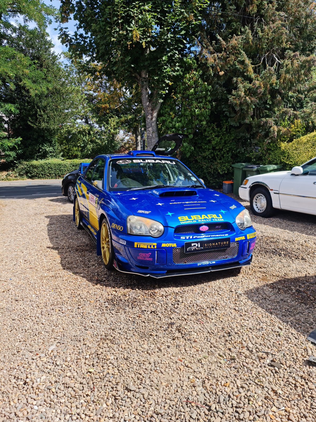 Blue Subaru with yellow rally graphics viewed from the front