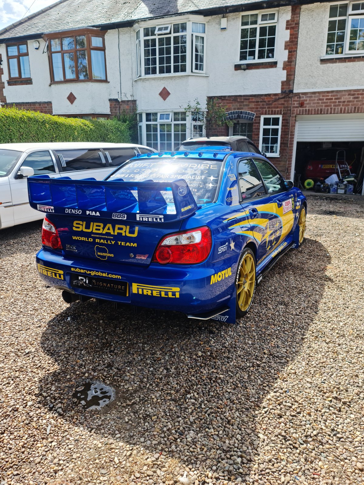 Blue Subaru with rally graphics viewed from the rear