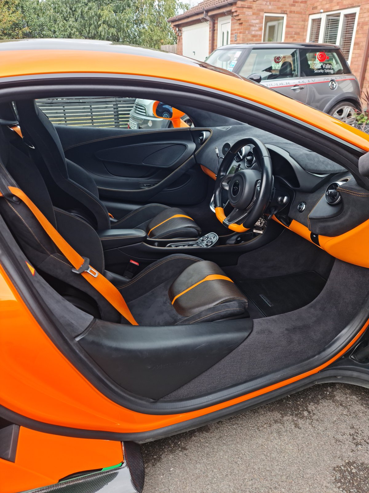 McLaren cabin with the door open, showing the seats and dashboard