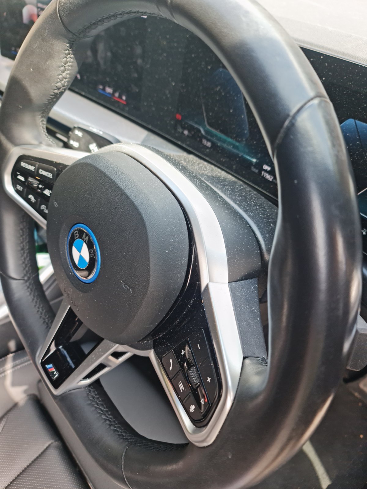 BMW steering wheel before detailing, with visible marks on the leather and controls