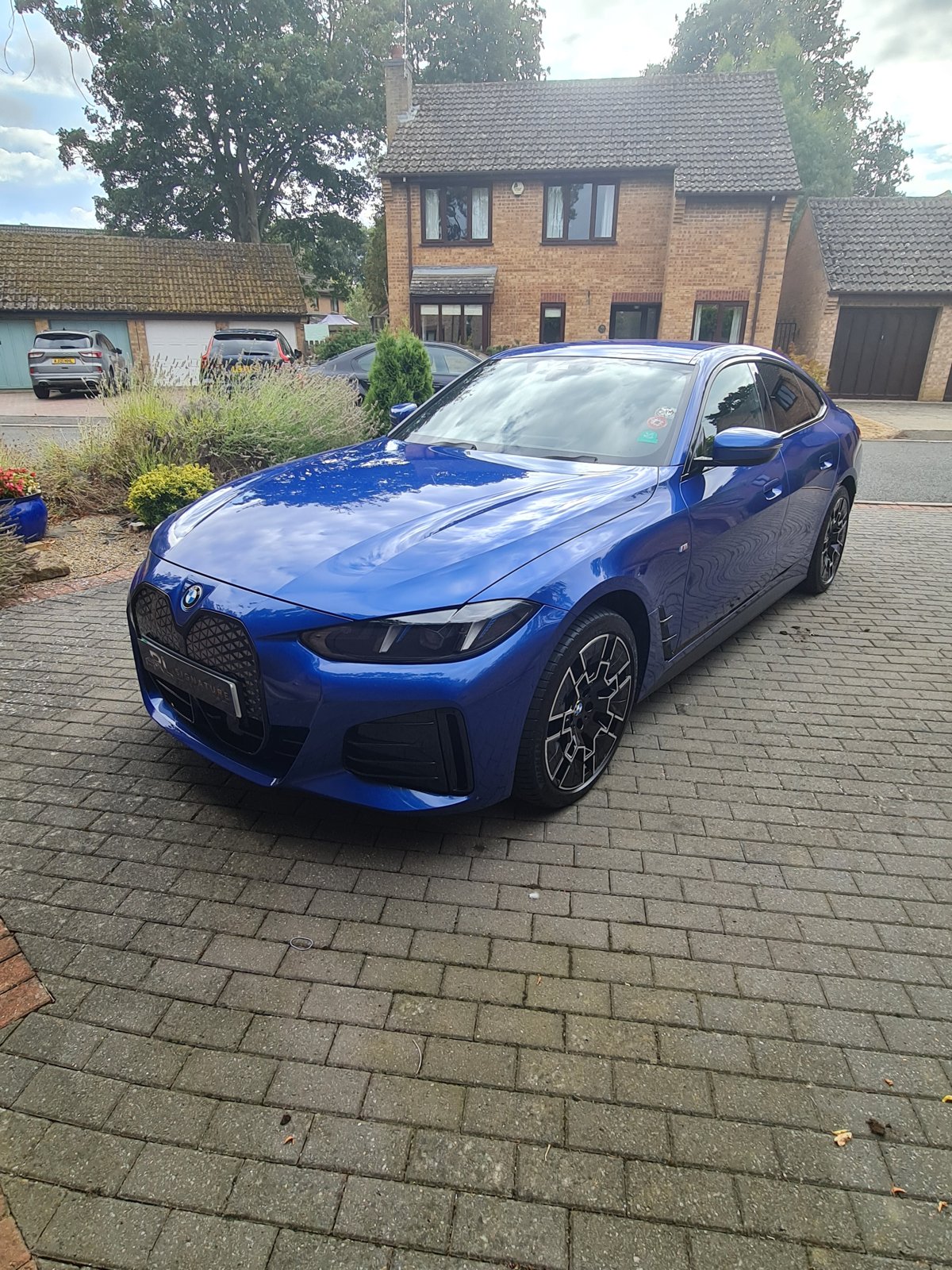 Finished blue BMW viewed from the front on a driveway