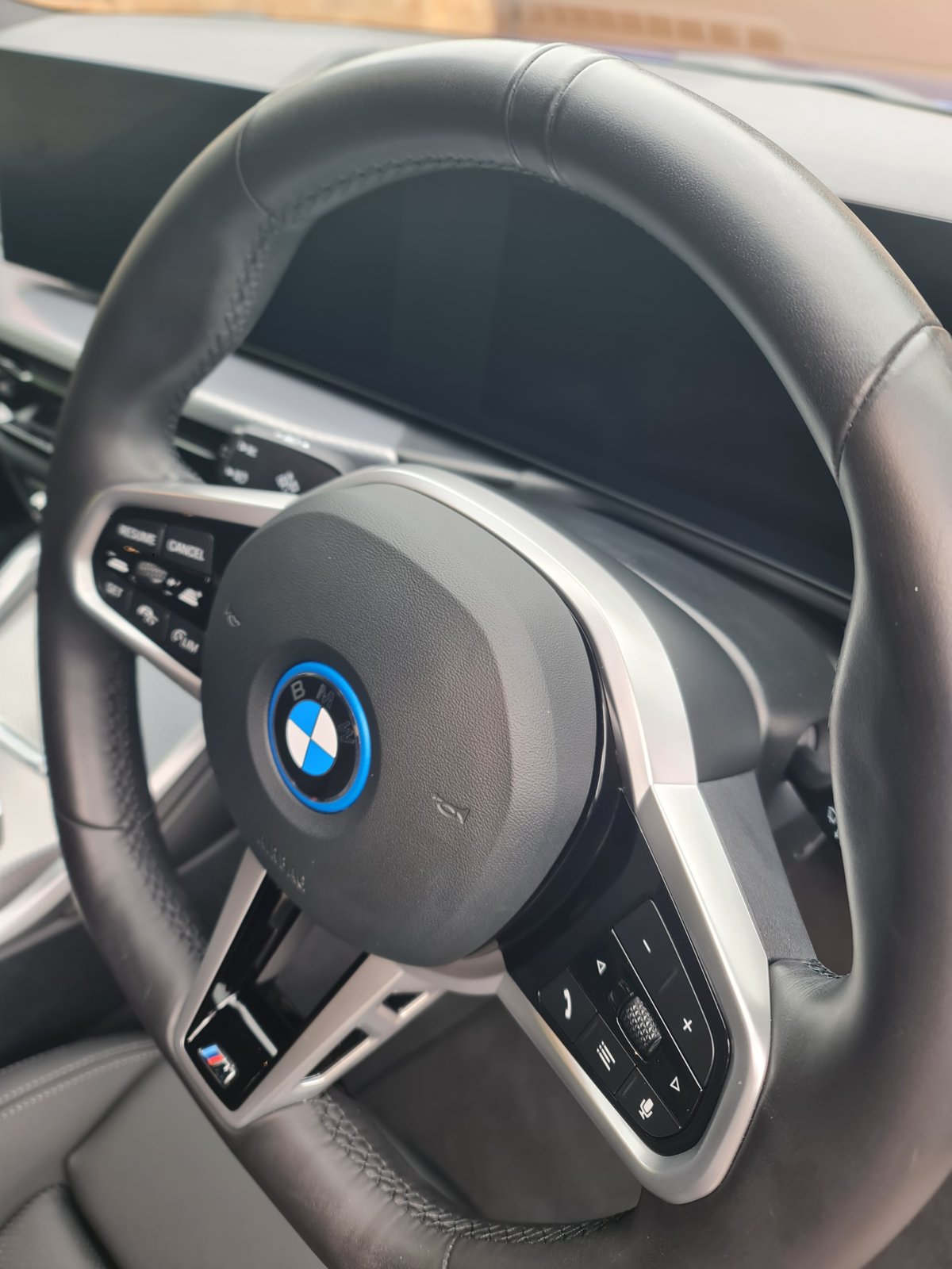 BMW steering wheel after detailing, showing the cleaned leather and controls
