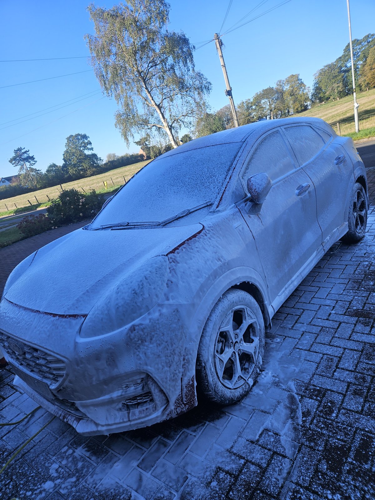 Vehicle exterior covered in foam during a detailing wash