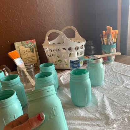 Hand-painted mint Mason jars in the workspace