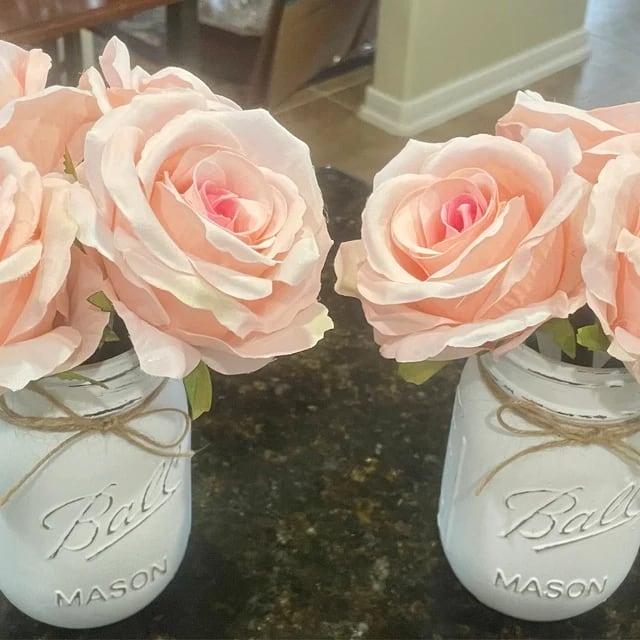 Peach flower pens arranged in painted Mason jars at home