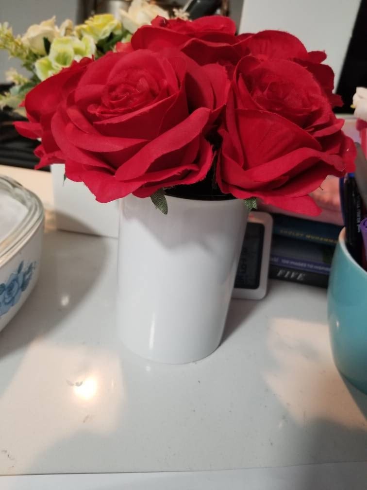 Red rose flower pens in a white pitcher