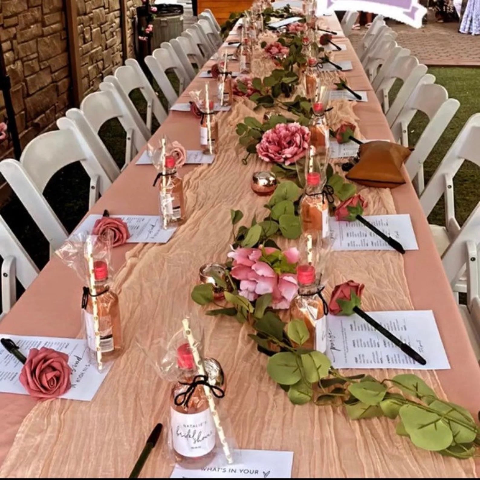 Long celebration table decorated with pink flowers and handmade details