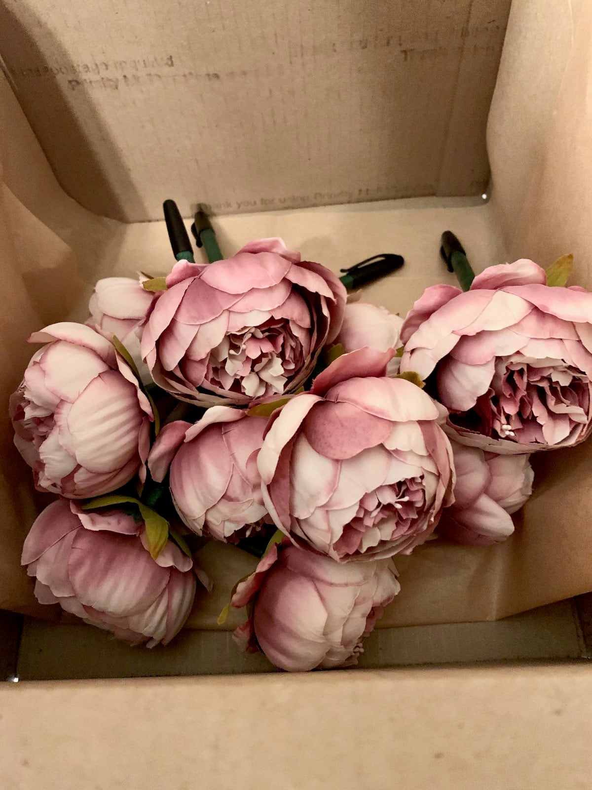 Handmade dusty rose flower pens gathered in a box