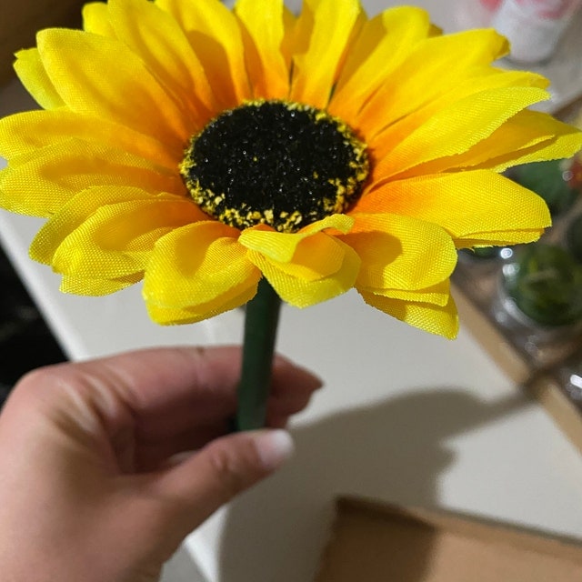 Bright yellow sunflower flower pen held by a customer