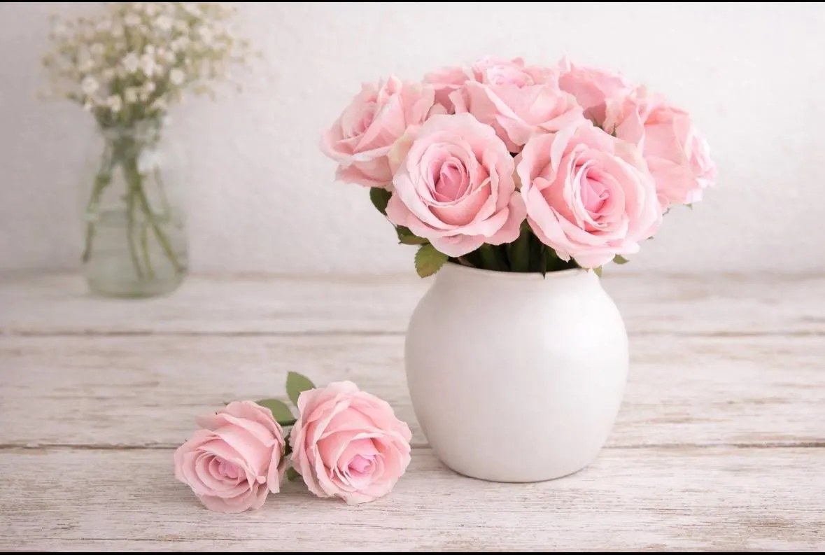 Pink rose flower pens arranged together in a white vase