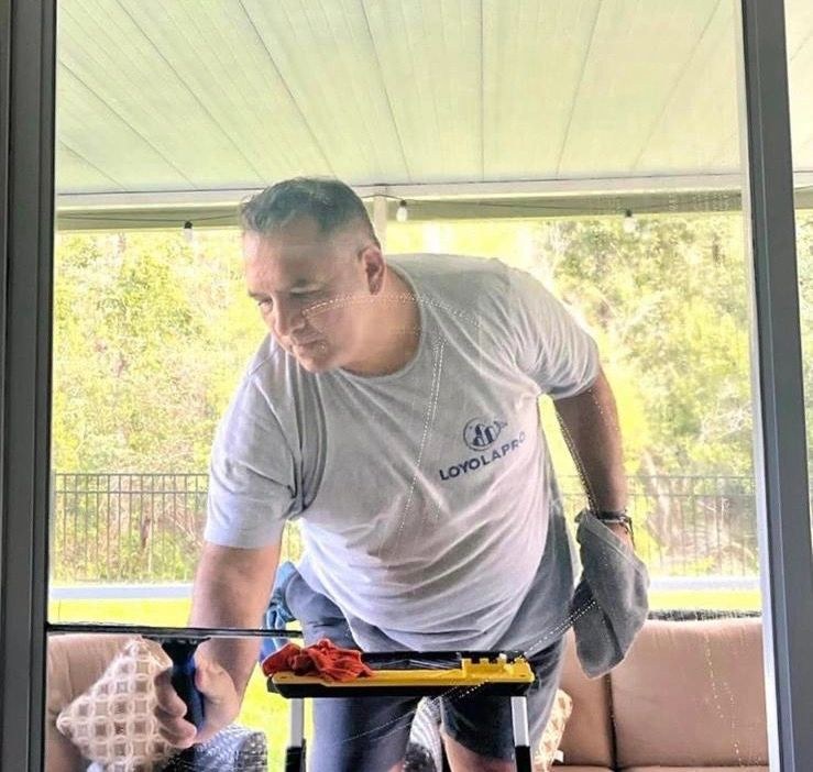 Loyola Pro team member cleaning a window