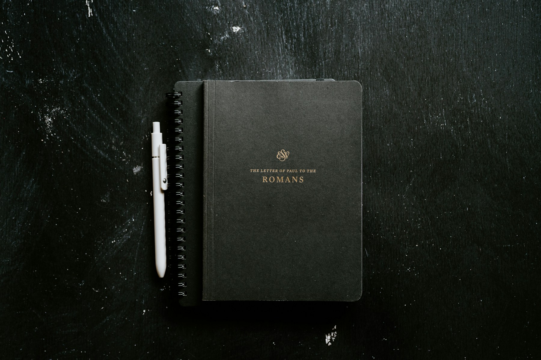A notebook and pen beside a devotional book for a quiet prayer rhythm