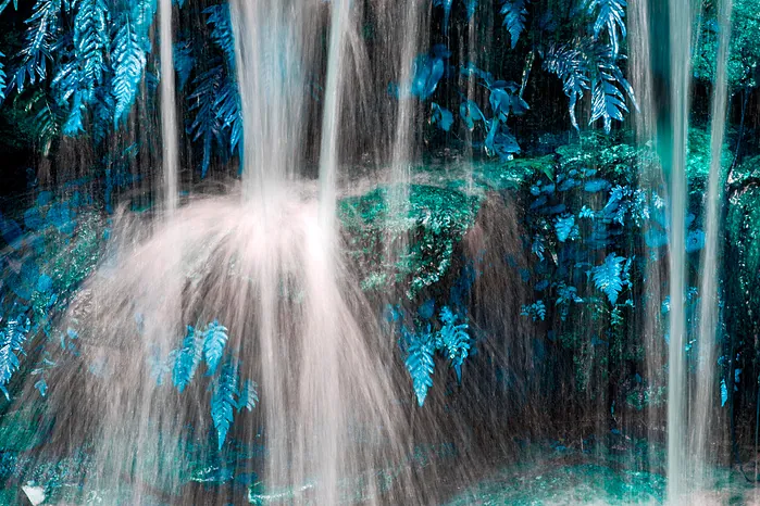 A color photograph of a waterfall and rock face.