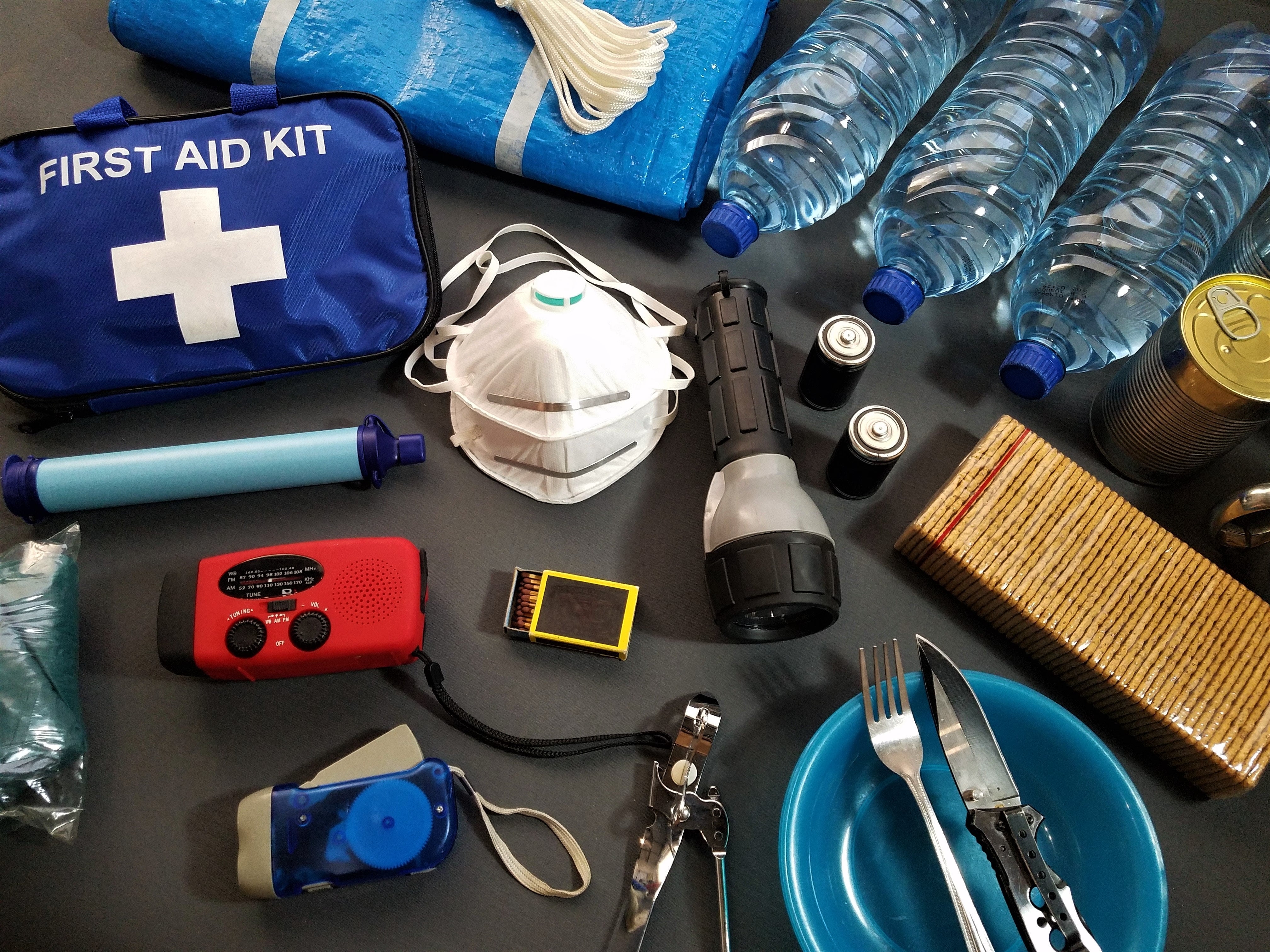A household contact plan, map, flashlight, and battery radio arranged on a table