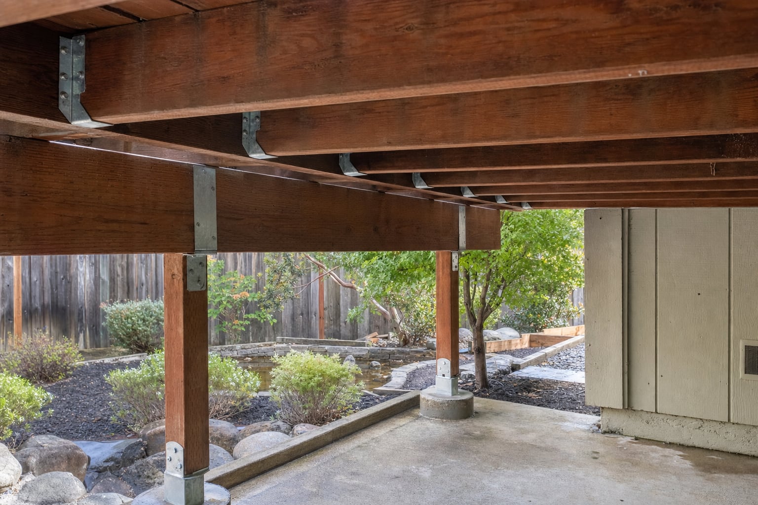 Wood deck framing and posts being inspected for condition