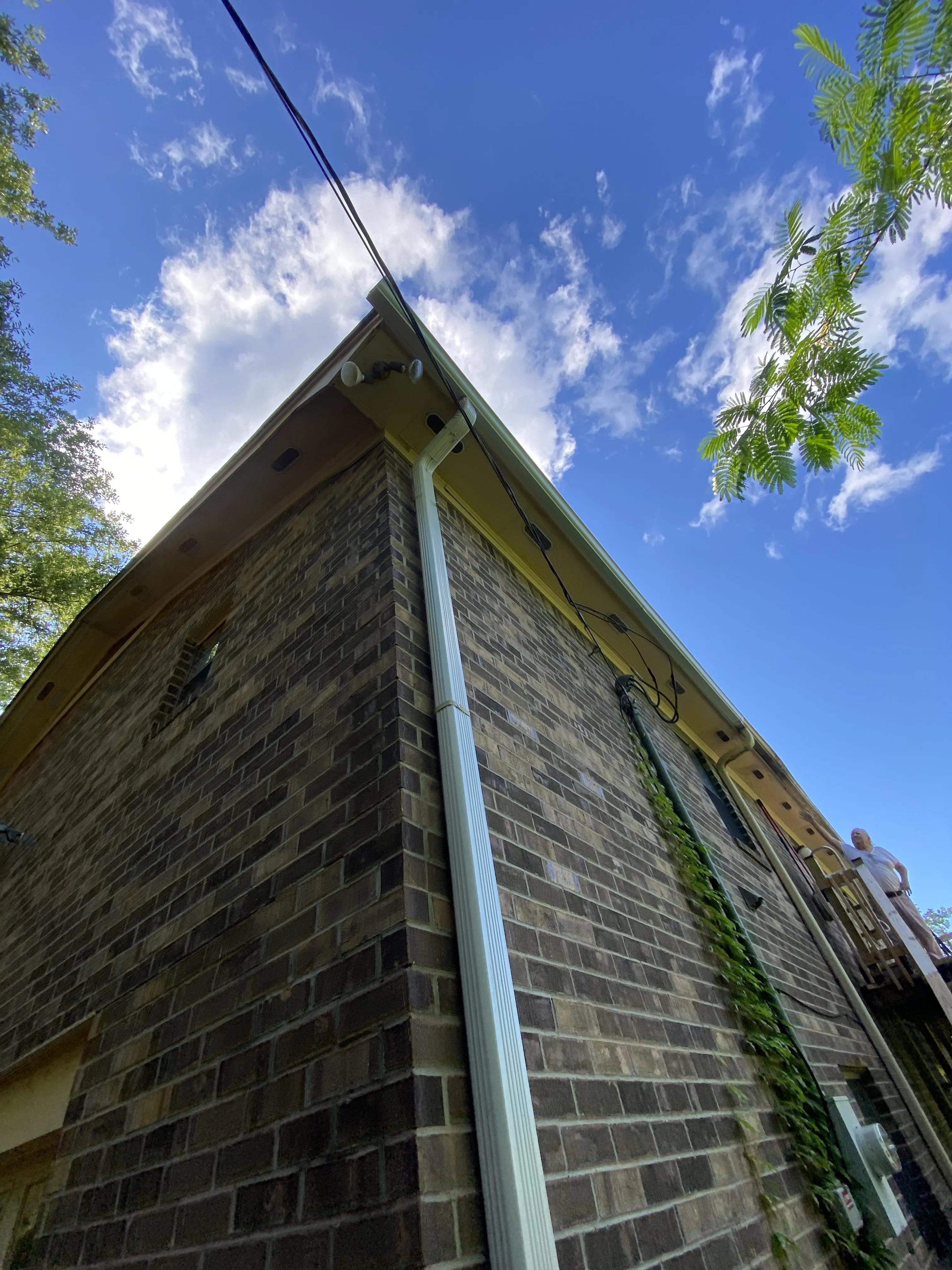 Gutter and downspout at the corner of a brick home
