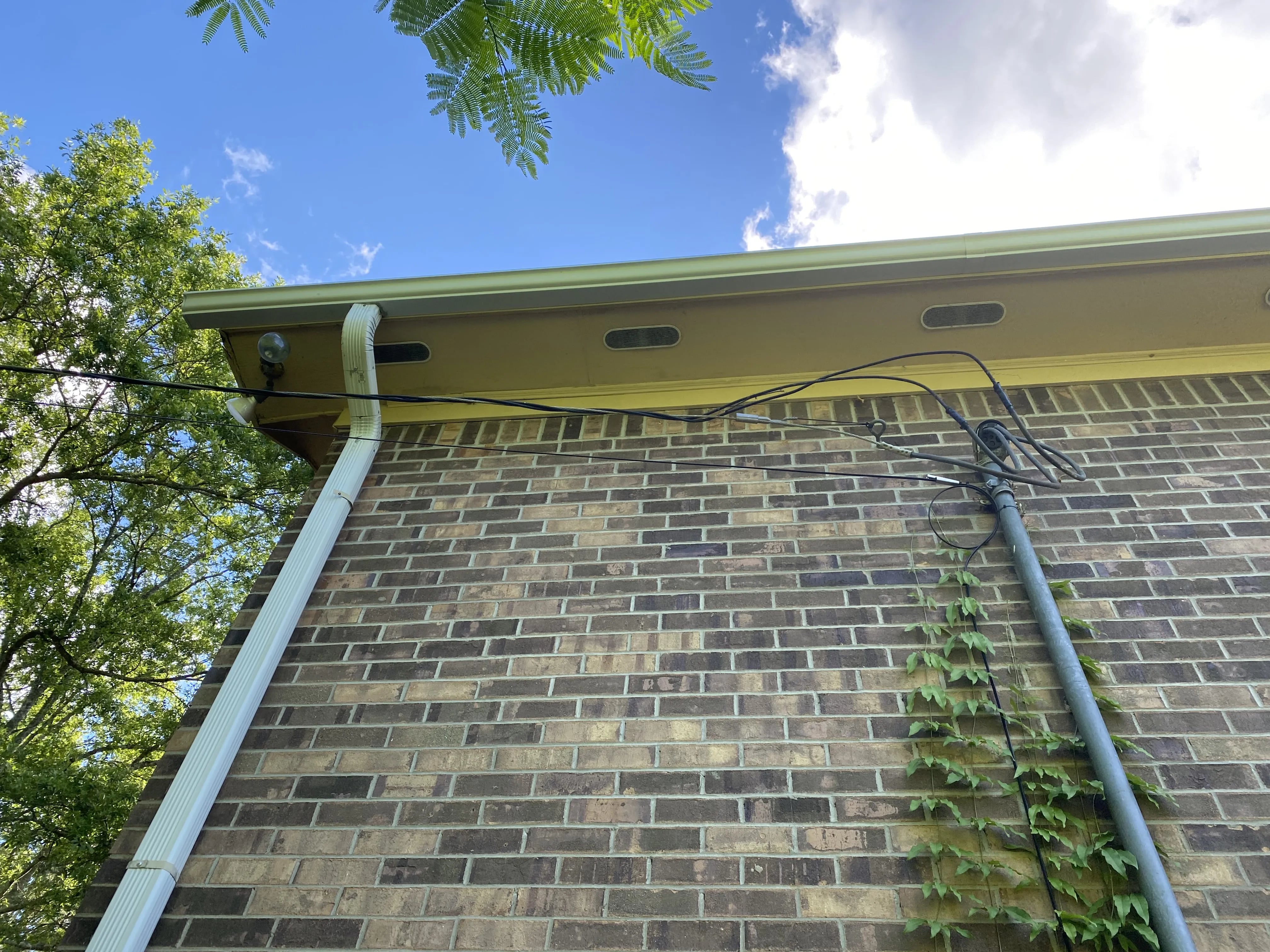 Gutter run and downspout along a brick exterior wall